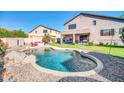 Spacious backyard with a uniquely shaped pool, rock features, and ample patio space for entertaining at 4408 W Summerside Rd, Laveen, AZ 85339
