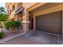 Attached one-car garage and a red front door situated next to a manicured shrub at 4465 E Paradise Village S Pkwy # 1224, Phoenix, AZ 85032