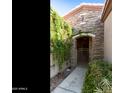 Stone archway entrance with wrought iron gate, framed by lush plants and greenery at 4548 E Nightingale Ln, Gilbert, AZ 85298