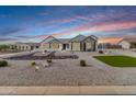 Beautiful single-story house with desert landscaping, updated exterior paint, and well-maintained lawn against the colorful sky at 460 W Chase St, San Tan Valley, AZ 85143