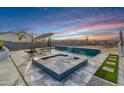 Backyard pool and spa feature modern tilework, a waterfall feature, and desert views for a relaxing outdoor oasis at 460 W Chase St, San Tan Valley, AZ 85143