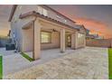 Backyard patio with travertine pavers, a covered area with a ceiling fan, and partial lawn at 550 E Zion Pl, Chandler, AZ 85249
