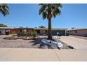 Inviting single-story home boasts mature palm trees, low-maintenance desert landscaping, and a tidy front yard at 6449 E Ellis St, Mesa, AZ 85205