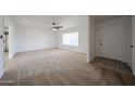 Expansive living room with neutral carpet, large window, and ceiling fan offering ample natural light at 6449 E Ellis St, Mesa, AZ 85205