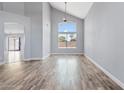 Bright living room features beautiful hardwood floors, high ceilings, and a large window providing ample natural light at 8750 W Granada Rd, Phoenix, AZ 85037