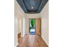 Inviting foyer with hardwood floors, decorative ceiling and wooden door leading to the front yard at 8760 N 73Rd Way, Scottsdale, AZ 85258