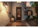 A close-up of the front door with stonework, wrought iron, and a decorative light fixture at 9310 S Bala Dr, Tempe, AZ 85284