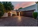 Brick driveway featuring an attached garage with wooden doors and a side gate at 9310 S Bala Dr, Tempe, AZ 85284