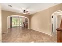 Open-concept living room featuring tile floors, arched doorways, and access to the backyard patio at 1612 W Lacewood Pl, Phoenix, AZ 85045