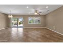 Bright living room featuring tile flooring, backyard access, large windows, and neutral wall color at 16525 W Tranquility Ln, Surprise, AZ 85387