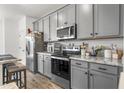 Contemporary kitchen with granite countertops, stainless steel appliances, and gray cabinetry at 16824 W Alice Ave, Waddell, AZ 85355