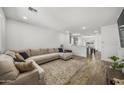 Bright living room with neutral tones, wood-look floors, and a comfortable sectional sofa at 16824 W Alice Ave, Waddell, AZ 85355