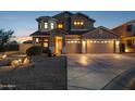 Two-story home featuring three-car garage, red tile roof, desert landscaping, and a covered porch entry at 18121 E San Luis Dr, Gold Canyon, AZ 85118