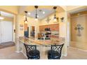 Stylish kitchen featuring granite countertops, a breakfast bar, and modern pendant lighting at 2124 W Harwell Rd, Phoenix, AZ 85041