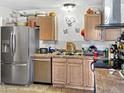 Galley kitchen with stainless steel refrigerator, stainless steel dishwasher and tile floor at 3627 W Hayward Ave, Phoenix, AZ 85051
