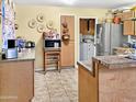 Galley kitchen with appliances, cabinets, laminate countertops and tile floor at 3627 W Hayward Ave, Phoenix, AZ 85051
