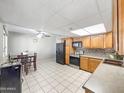Eat in kitchen with wood cabinets, tile backsplash and black appliances at 4122 W Las Palmaritas Dr, Phoenix, AZ 85051