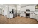 Spacious kitchen with stainless steel appliances, white cabinets, subway tile backsplash, and pantry at 42510 W Peters Dr, Maricopa, AZ 85138
