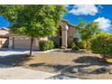 Inviting single-story home with desert landscaping, mature trees, and a welcoming entrance with a covered porch at 4626 E Summerhaven Dr, Phoenix, AZ 85044