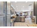Open kitchen with stainless steel appliances, granite countertops, and gray cabinets provides a modern look at 4626 E Summerhaven Dr, Phoenix, AZ 85044