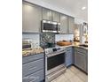 Close-up of kitchen features stainless steel oven and microwave with granite countertops and tile backsplash at 4626 E Summerhaven Dr, Phoenix, AZ 85044
