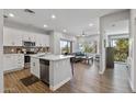 Open-concept living space with kitchen island, stainless appliances, wood flooring, and a view to the outside at 475 N 9Th St # 206, Phoenix, AZ 85006