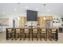 A spacious kitchen island with barstool seating, a matte black hood, and modern cabinetry at 5937 E Corrine Dr, Scottsdale, AZ 85254