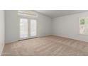 Light-filled bedroom with plush carpeting, a window, and french doors at 6420 W Beverly Ln, Glendale, AZ 85306