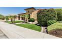 Inviting home exterior boasts manicured landscaping, decorative shrubbery, and a well-maintained lawn at 7242 W Rowel Rd, Peoria, AZ 85383