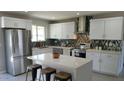 Modern kitchen featuring white cabinets, stainless steel appliances, quartz countertops and decorative backsplash at 8750 E Starlight Way, Scottsdale, AZ 85250