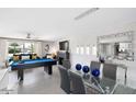 Open-concept living space with a pool table, dining area, and contemporary decor, perfect for entertaining at 8750 E Starlight Way, Scottsdale, AZ 85250