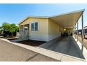 Single story home with butterscotch siding, covered parking and well-kept landscaping at 8832 E Pueblo Ave # 71, Mesa, AZ 85208