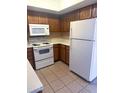 Functional kitchen showcasing white appliances, light countertops, and ample wooden cabinetry at 1075 E Chandler Blvd # 220, Chandler, AZ 85225