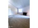 Bright living room featuring plush carpeting, a cozy fireplace, and natural light from a large window at 1075 E Chandler Blvd # 220, Chandler, AZ 85225