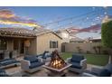 Inviting backyard patio area with outdoor seating, a fire pit, and string lights at 12152 W Briles Rd, Peoria, AZ 85383