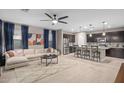 Open-concept living room and kitchen area with a plush sofa, island seating, and modern finishes at 12152 W Briles Rd, Peoria, AZ 85383