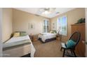 Cozy bedroom featuring two twin beds, plantation shutters, neutral decor, and ample natural light at 13295 N 153Rd Ln, Surprise, AZ 85379