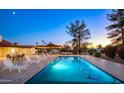 Backyard pool with lounge chairs, outdoor dining, and a built-in barbeque area with mountain views at 13620 N 80Th Pl, Scottsdale, AZ 85260