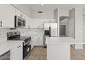 Bright kitchen boasts white cabinets, stainless steel appliances, and center island, blending style and functionality at 1453 E South Fork Dr, Phoenix, AZ 85048