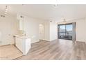 Open living room with wood floors flows to a kitchen area and a sliding glass door with balcony at 1701 E Colter St # 491, Phoenix, AZ 85016
