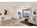 This staged living room features a sofa, large windows, and a television at 1701 E Colter St # 491, Phoenix, AZ 85016