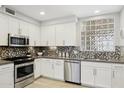 Modern kitchen with stainless steel appliances, gray counters, diamond pattern backsplash, and decorative glass block window at 17850 N 68Th St # 2138, Phoenix, AZ 85054