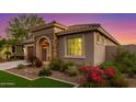 Well-maintained single-story home featuring manicured landscaping, a stone archway, and a cozy entrance at 20783 W Pasadena Ave, Buckeye, AZ 85396