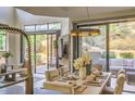 Elegant dining room with desert landscape views, stylish table setting, and adjacent living area at 25555 N Windy Walk Dr # 69, Scottsdale, AZ 85255