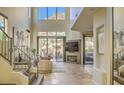 Bright living room with high ceilings, stone floors, fireplace, and views of the desert landscape at 25555 N Windy Walk Dr # 69, Scottsdale, AZ 85255