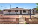 Quaint single-story house featuring a gated yard with red rock landscaping at 2721 W Luke Ave, Phoenix, AZ 85017