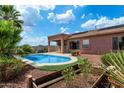Inviting backyard with a sparkling pool, covered patio, lush greenery, and desert views at 2761 W Via Calabria --, Phoenix, AZ 85086
