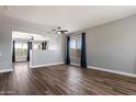 Spacious living room with wood floors, neutral walls, large windows, and modern ceiling fans at 2761 W Via Calabria --, Phoenix, AZ 85086