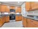 Well-lit kitchen features stainless steel appliances, light wood cabinetry, and beautiful granite countertops at 29356 N 67Th Ave, Peoria, AZ 85383