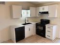 Bright kitchen features white cabinets, black appliances, and updated countertops at 3120 N 67Th Ln # 17, Phoenix, AZ 85033
